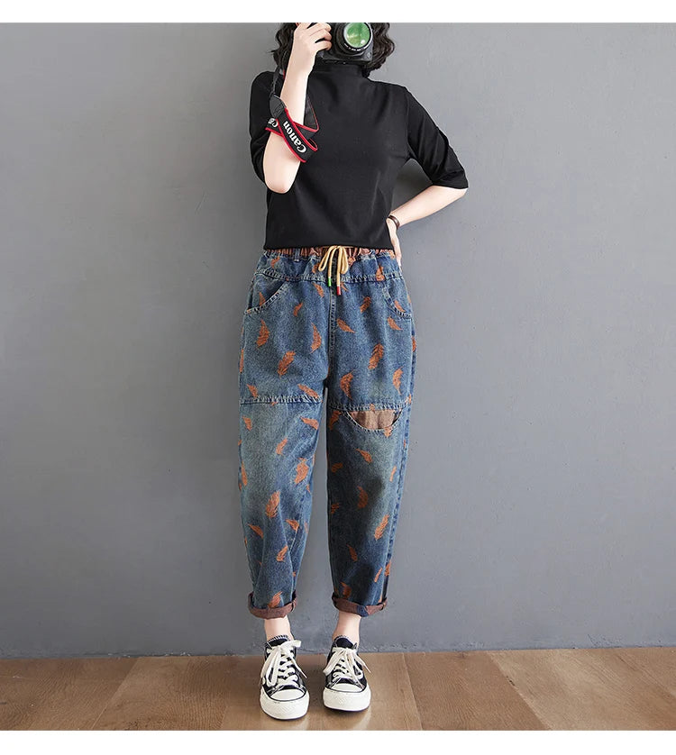 Jean femme style printemps, broderie plumes, contraste de couleurs, coupe ample, poches à cordon, taille élastique, pantalon en denim.