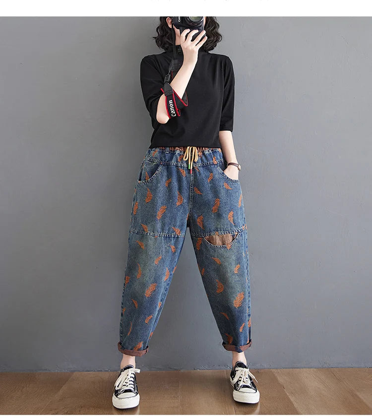 Jean femme style printemps, broderie plumes, contraste de couleurs, coupe ample, poches à cordon, taille élastique, pantalon en denim.